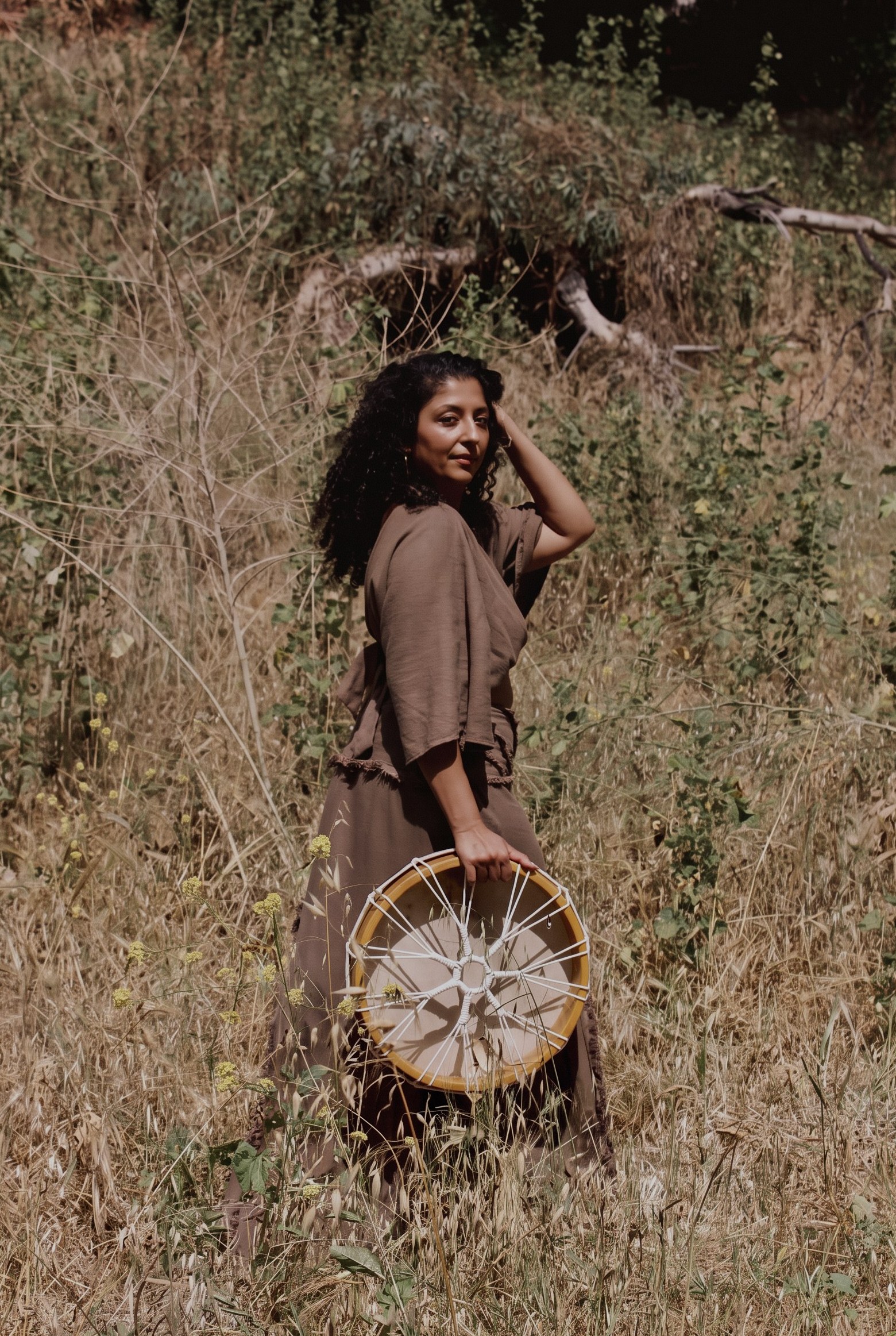 Tania Hansraj holding a drum in a field