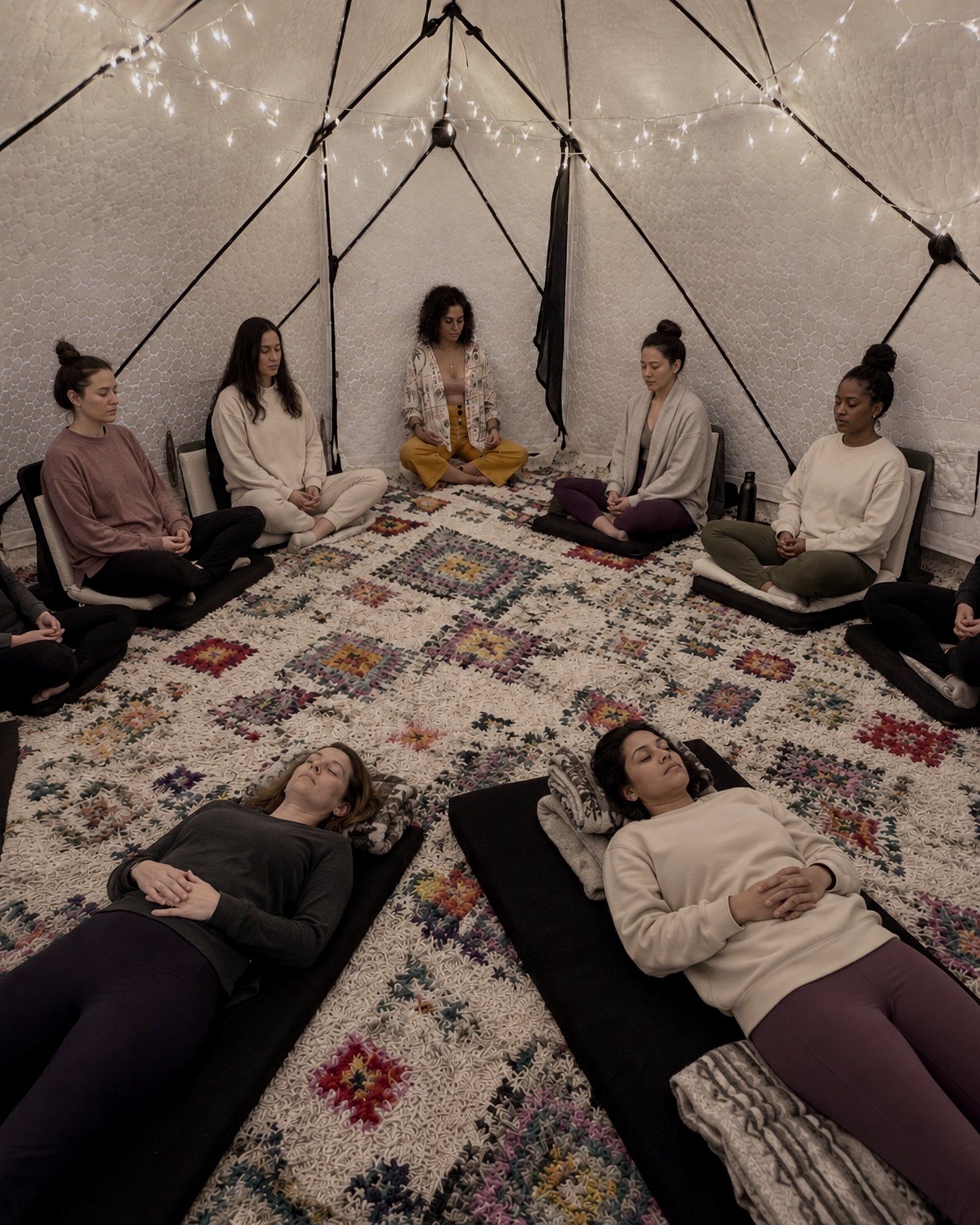 Women lying in a circle during a hypnosis workshop